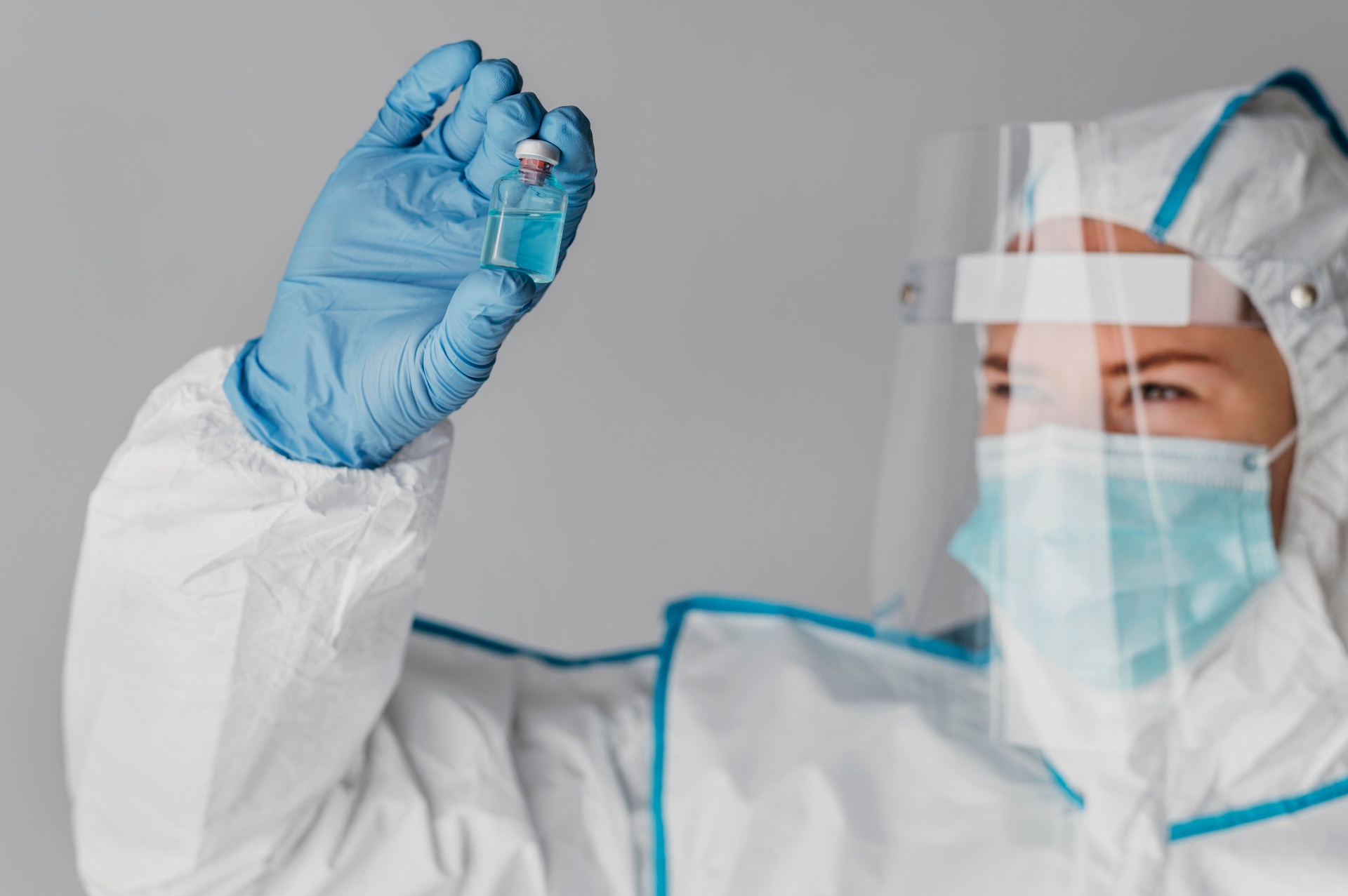 Arzt in Schutzausrüstung mit blauen Handschuhen
